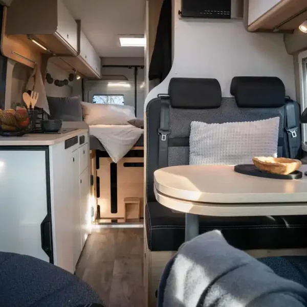 LMC Innovan Pure 640: Wohnebereich mit Sitzgruppe, Küche und Sicht auf den Schlafbereich